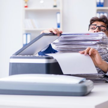 sfax online fax service features benefits man with glasses in office buried in files faxes fax machine